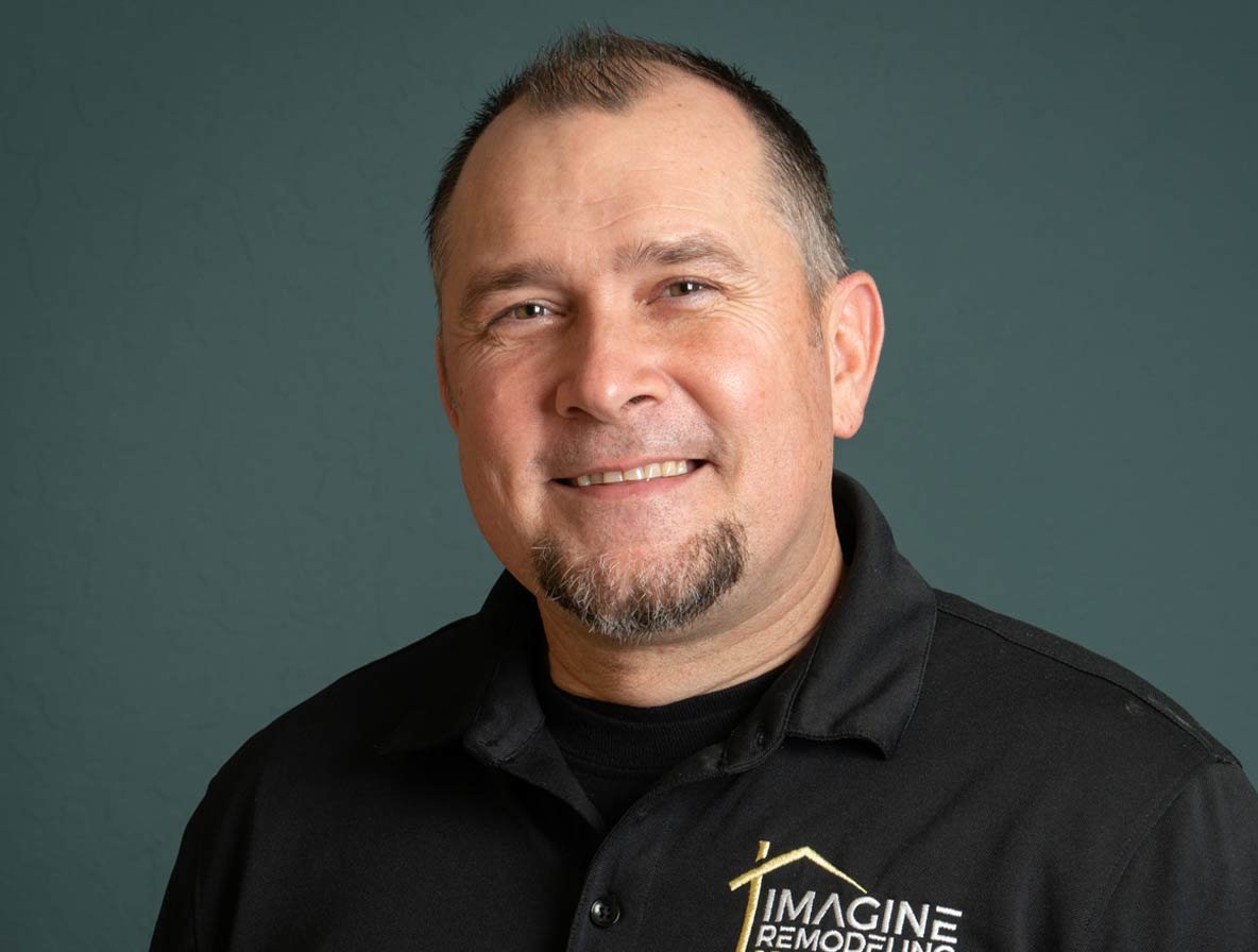 Tommy from Quick Bath Solutions standing in front of a teal background